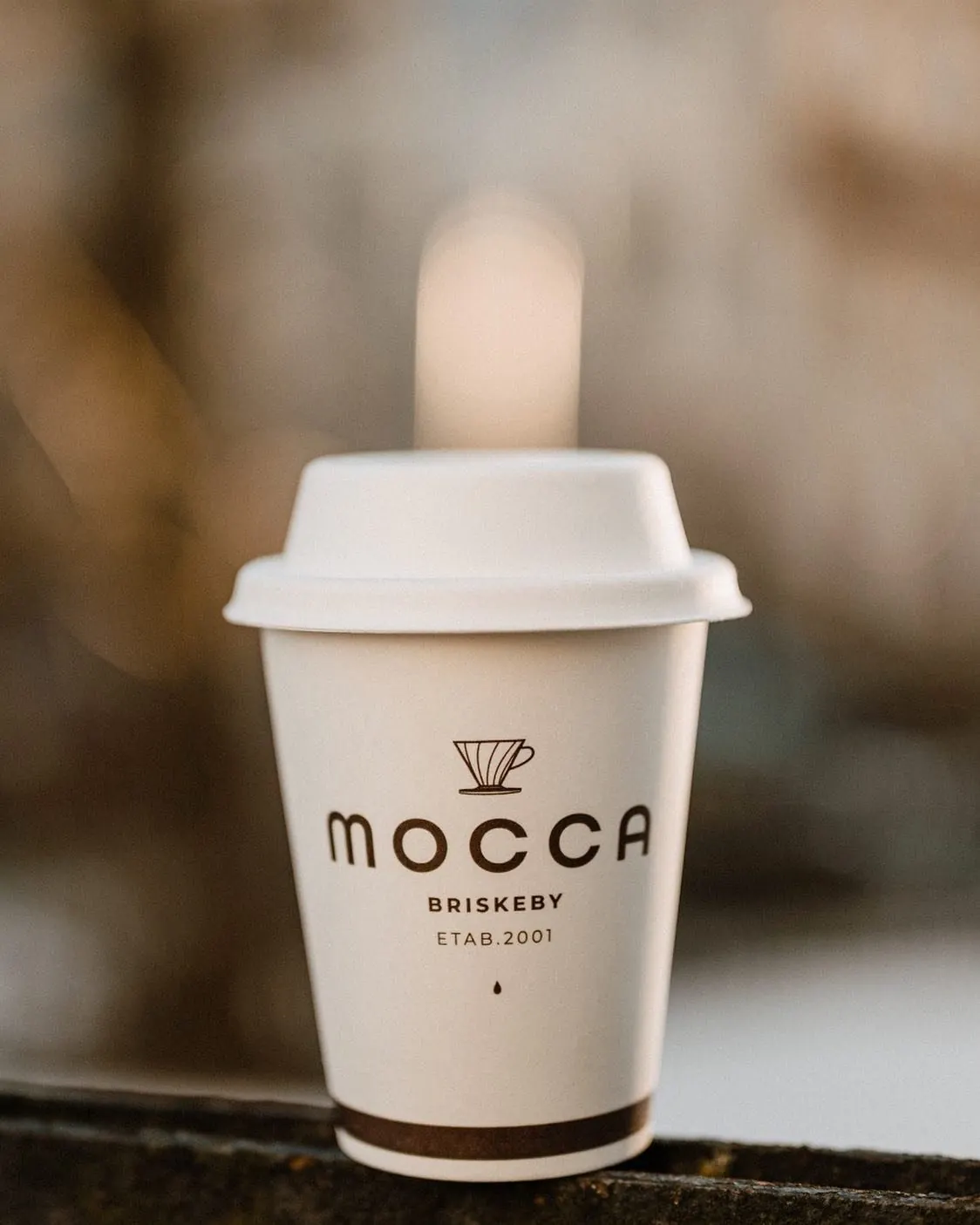 Hvit Mocca-kopp på en benk